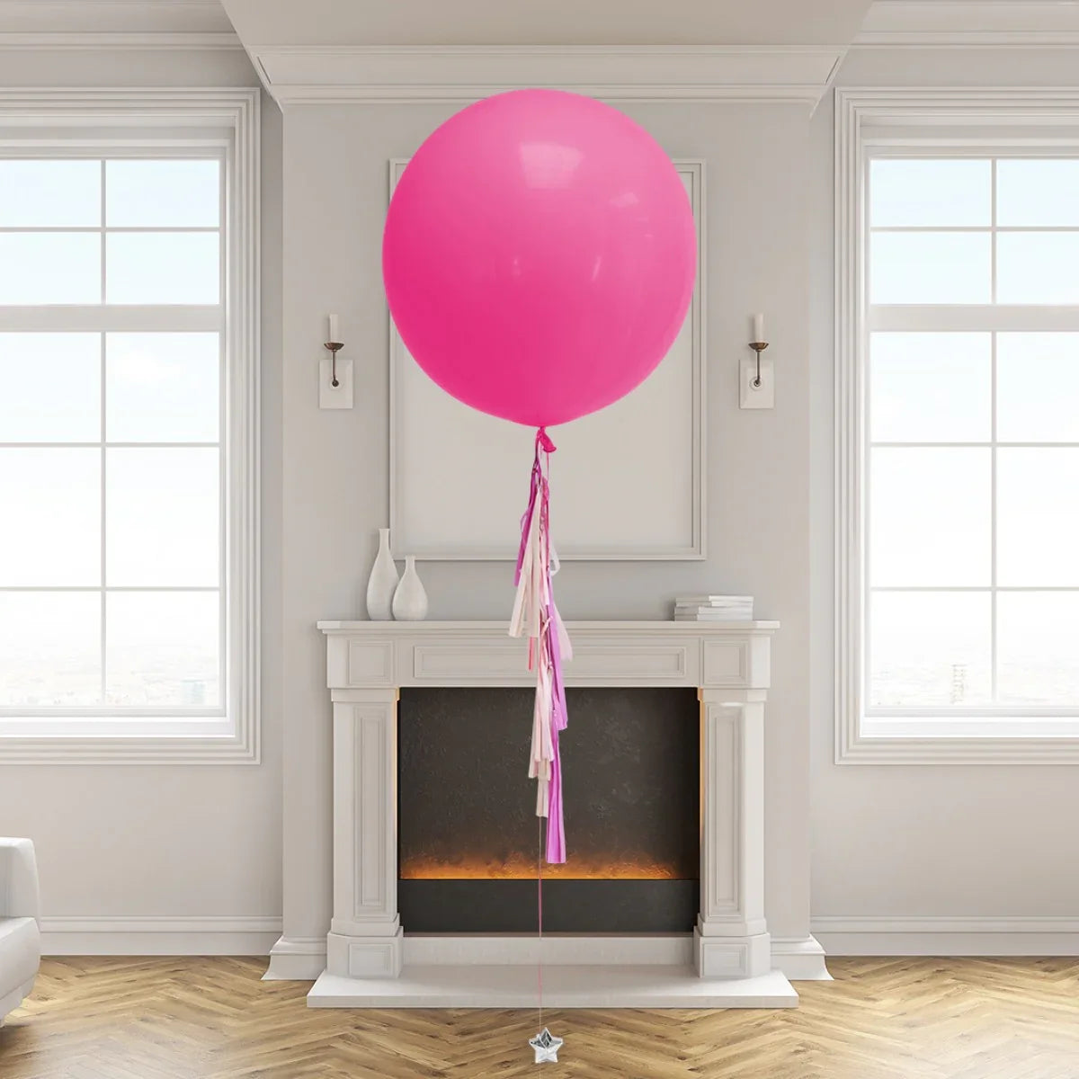 Pink pastel oversized balloon with tassels floating in elegant room with fireplace and large windows