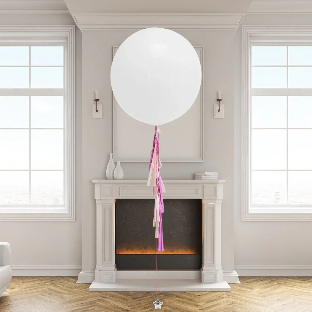 Large white helium balloon with pink and cream tassels in elegant living room with fireplace