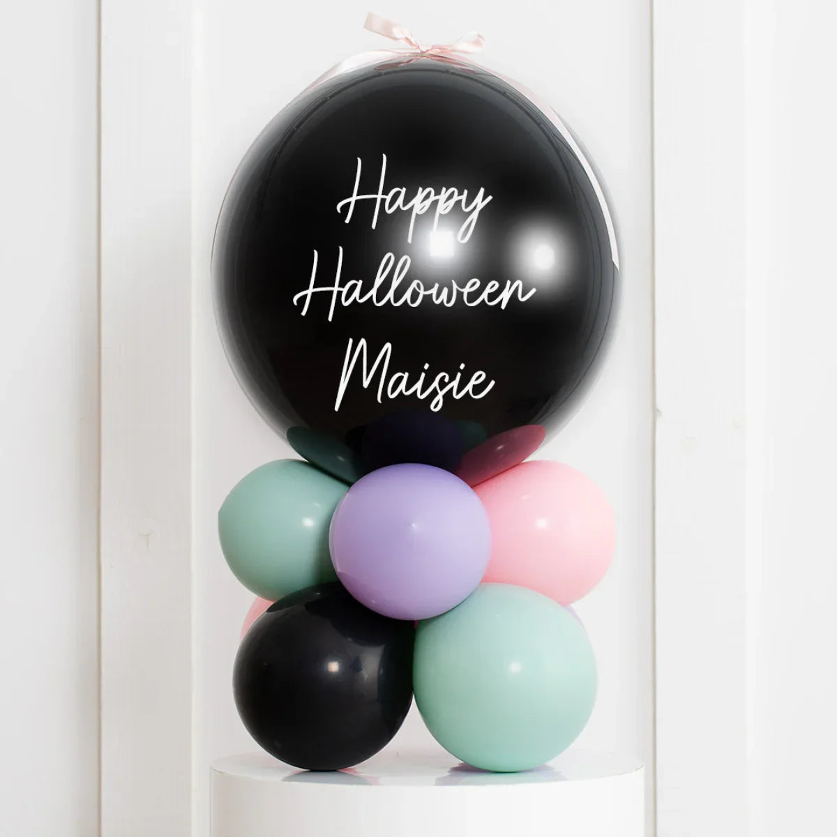 Personalised black Halloween balloon with white text and pastel pink, green, purple balloons beneath