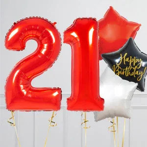 Red foil balloons shaped as number 21 with black and white star-shaped balloons, one reading Happy Birthday