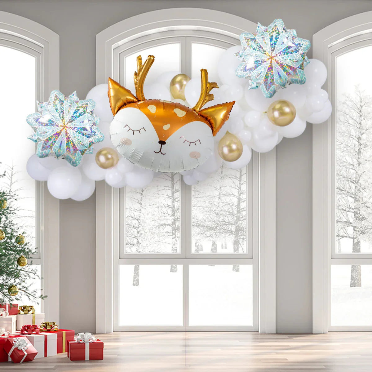 Festive winter balloon garland with gold reindeer balloon, white and gold balloons, and snowflake balloons in a snowy room