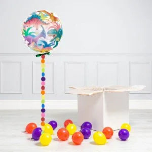 Colorful dinosaur-themed balloon with multicolor dot string and scattered orange, purple, and yellow balloons in room