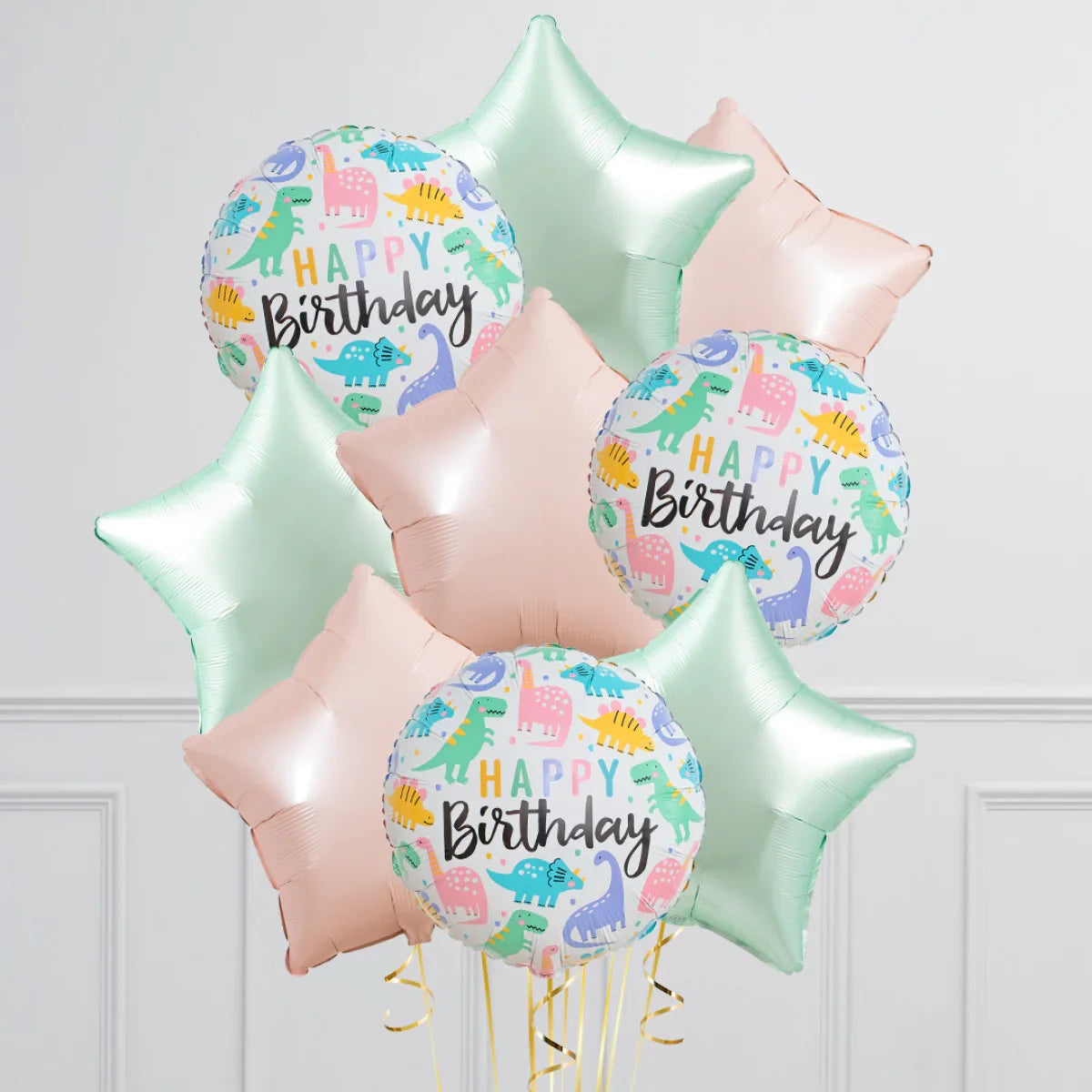 Happy Birthday balloons with colorful dinosaur prints and pastel star-shaped balloons in pink and mint green
