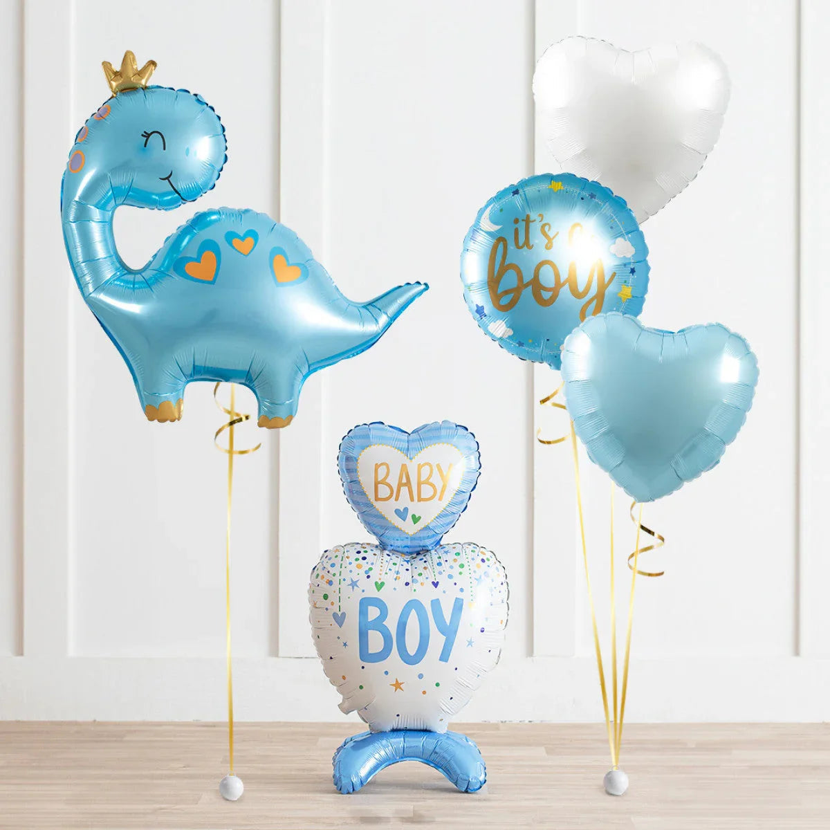 Blue and white baby boy shower balloons including a dinosaur balloon and heart-shaped balloons with baby boy messages