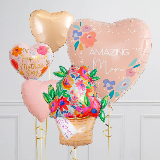 Colorful heart-shaped Mother's Day balloons including floral designs and messages in a white room
