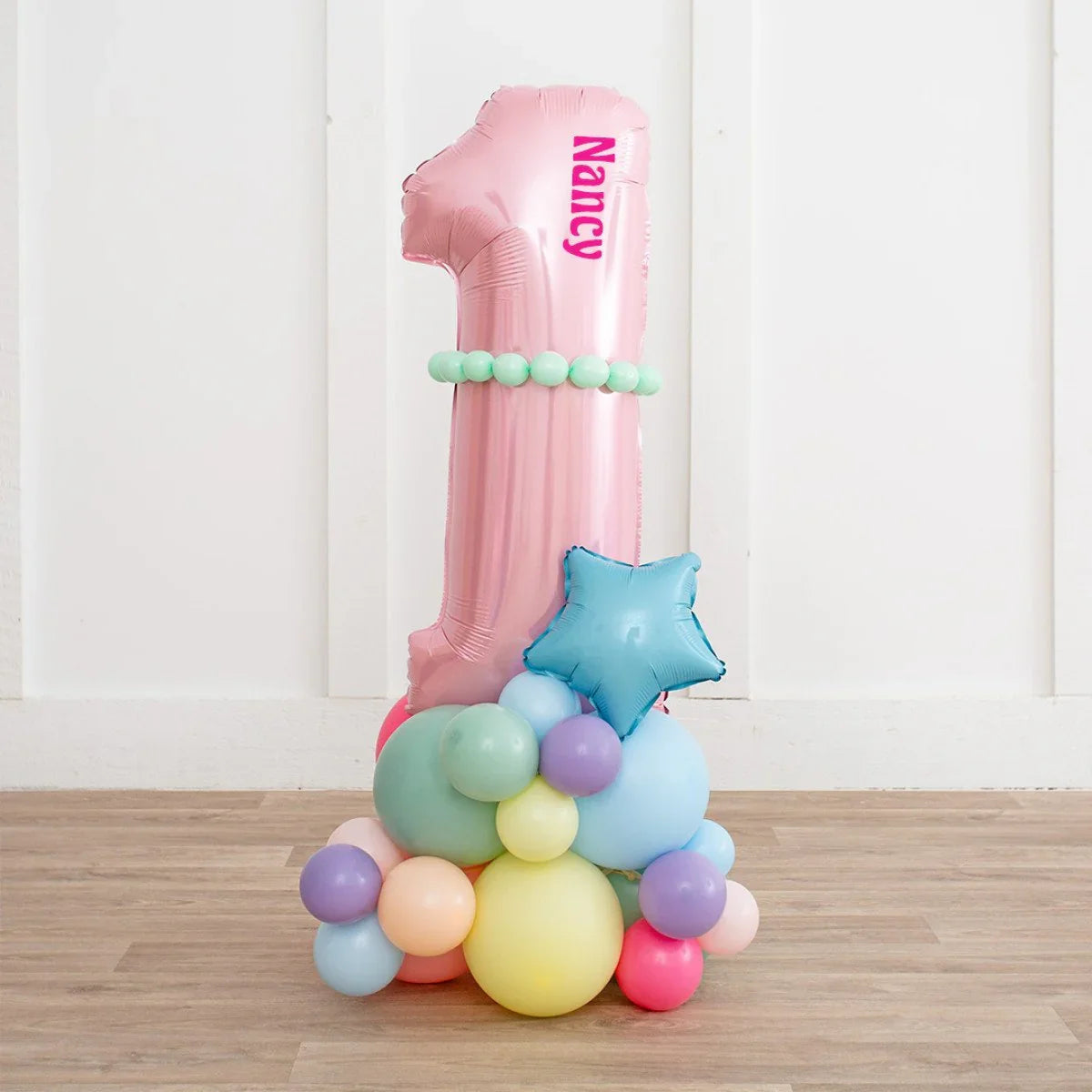 Personalized pink number 1 balloon with mint balloons and blue star balloon on pastel balloon cluster