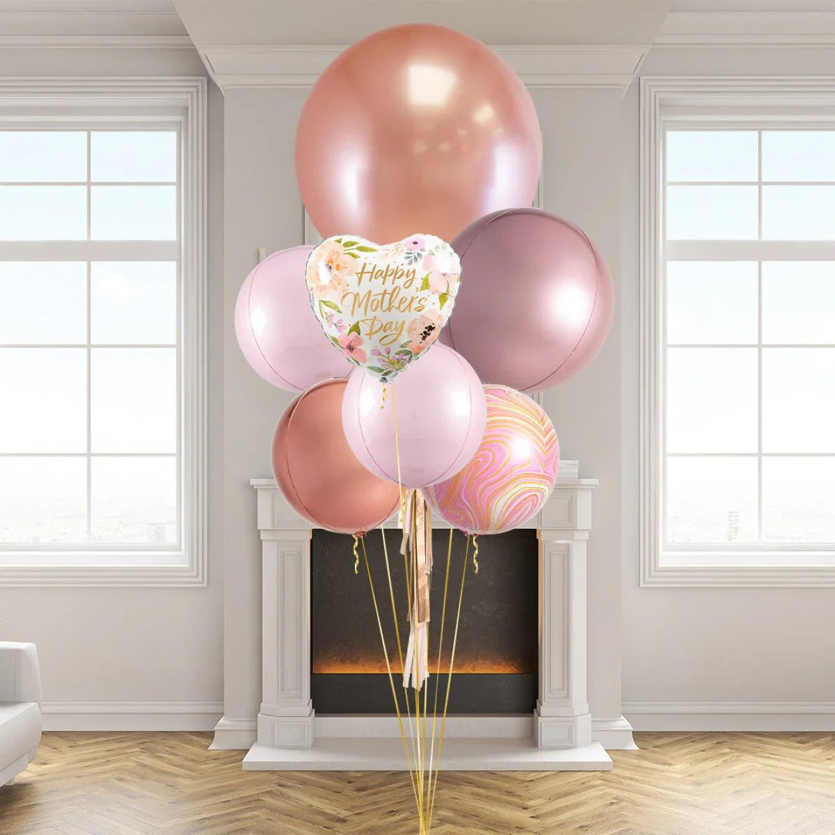 Rose gold and pink giant balloons with a floral Happy Mother's Day heart balloon in elegant living room