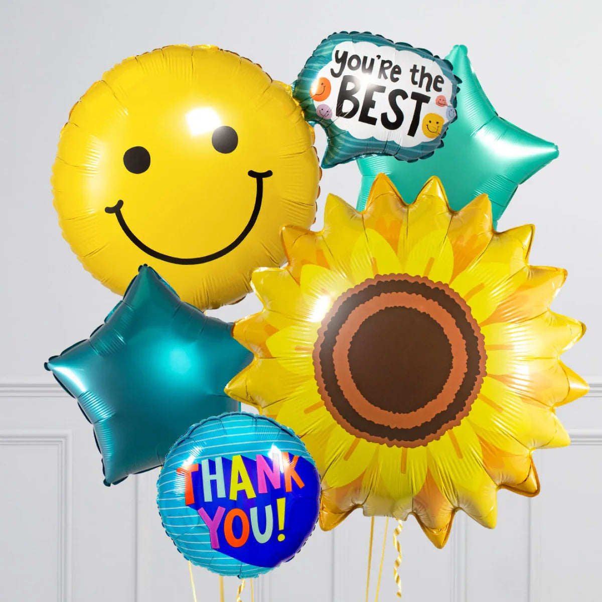 Bright thank you balloons including smiley face, sunflower, stars, and messages "you're the best" and "thank you"