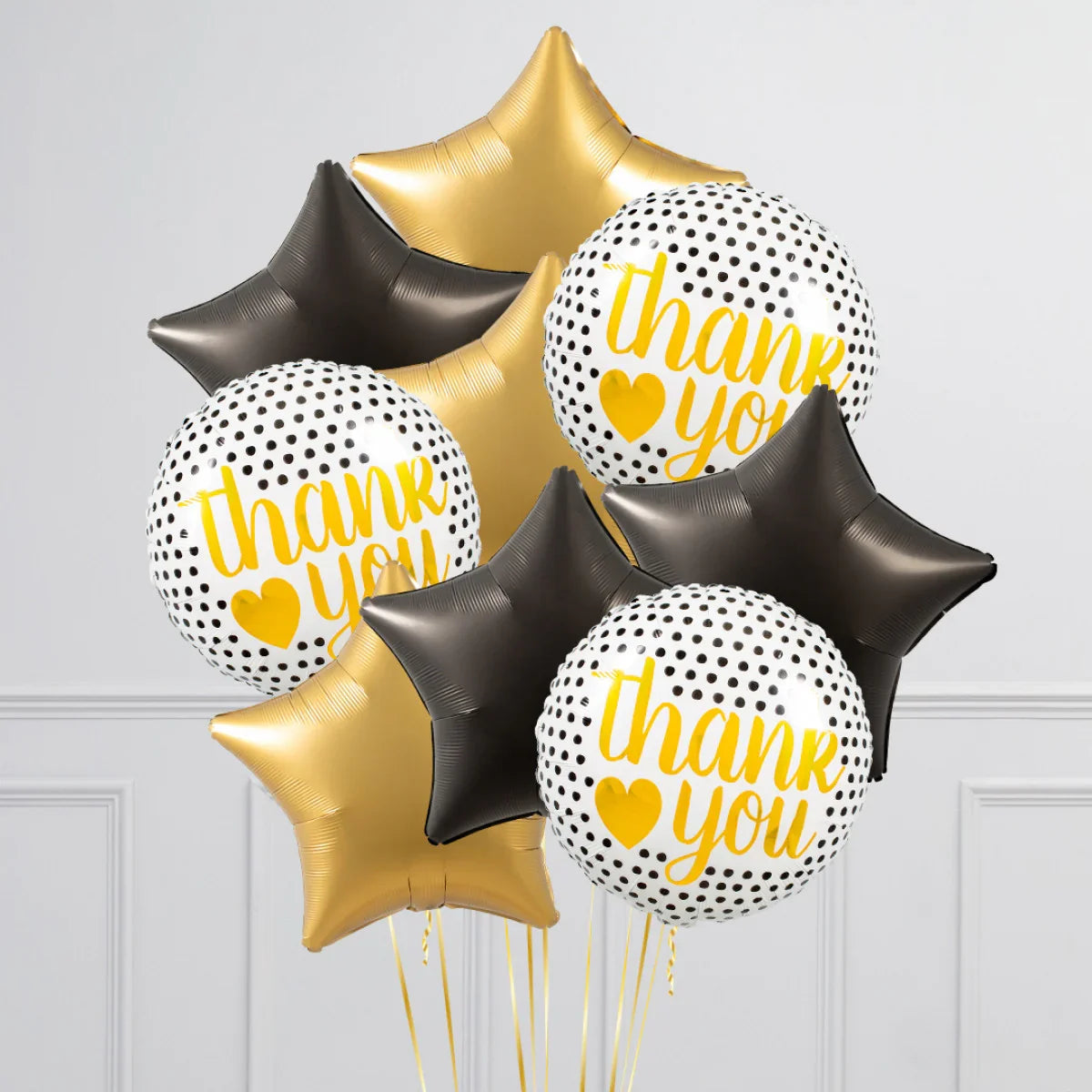 Black and gold star-shaped balloons with white polka dot balloons reading thank you in yellow