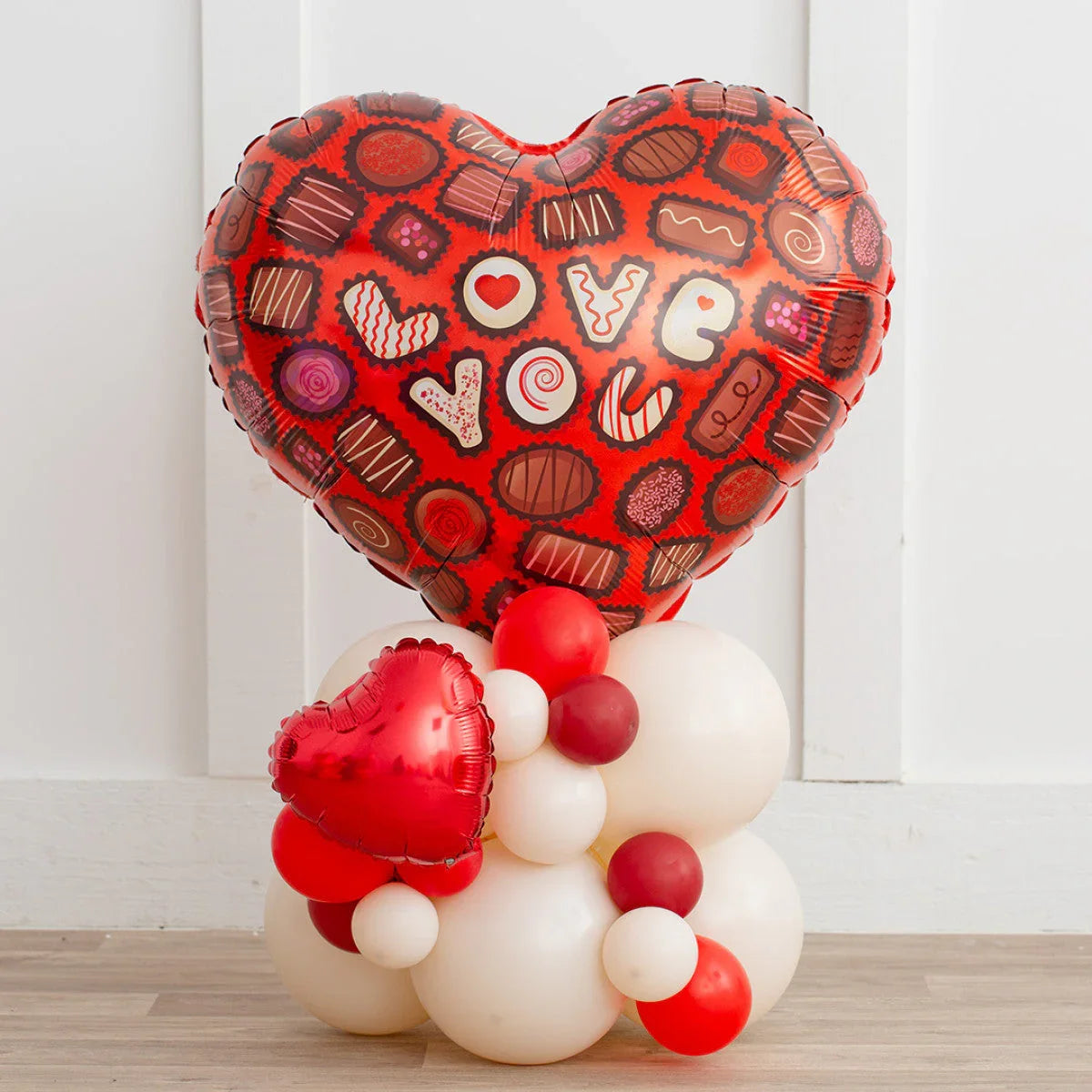 Valentine's Day red heart balloon with chocolate design saying 'love you' on white and red balloon base